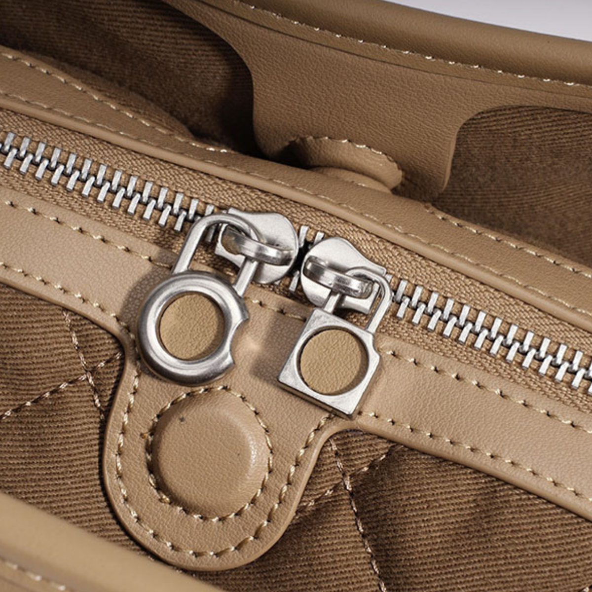 Close-up of tan woven leather handbag zipper with silver metal zipper