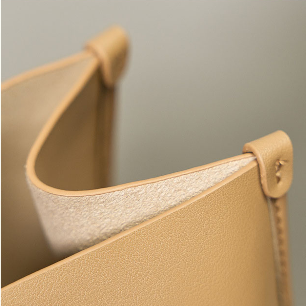 Leather tote bag edge with light lining and detailed stitching at the corner