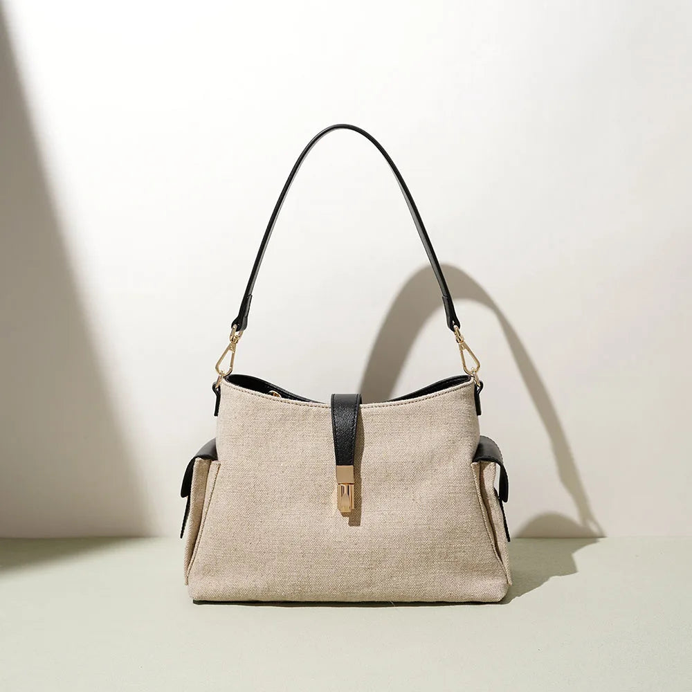 Oat and Onyx leather shoulder bag with top handles, zipper front and side tassel ties