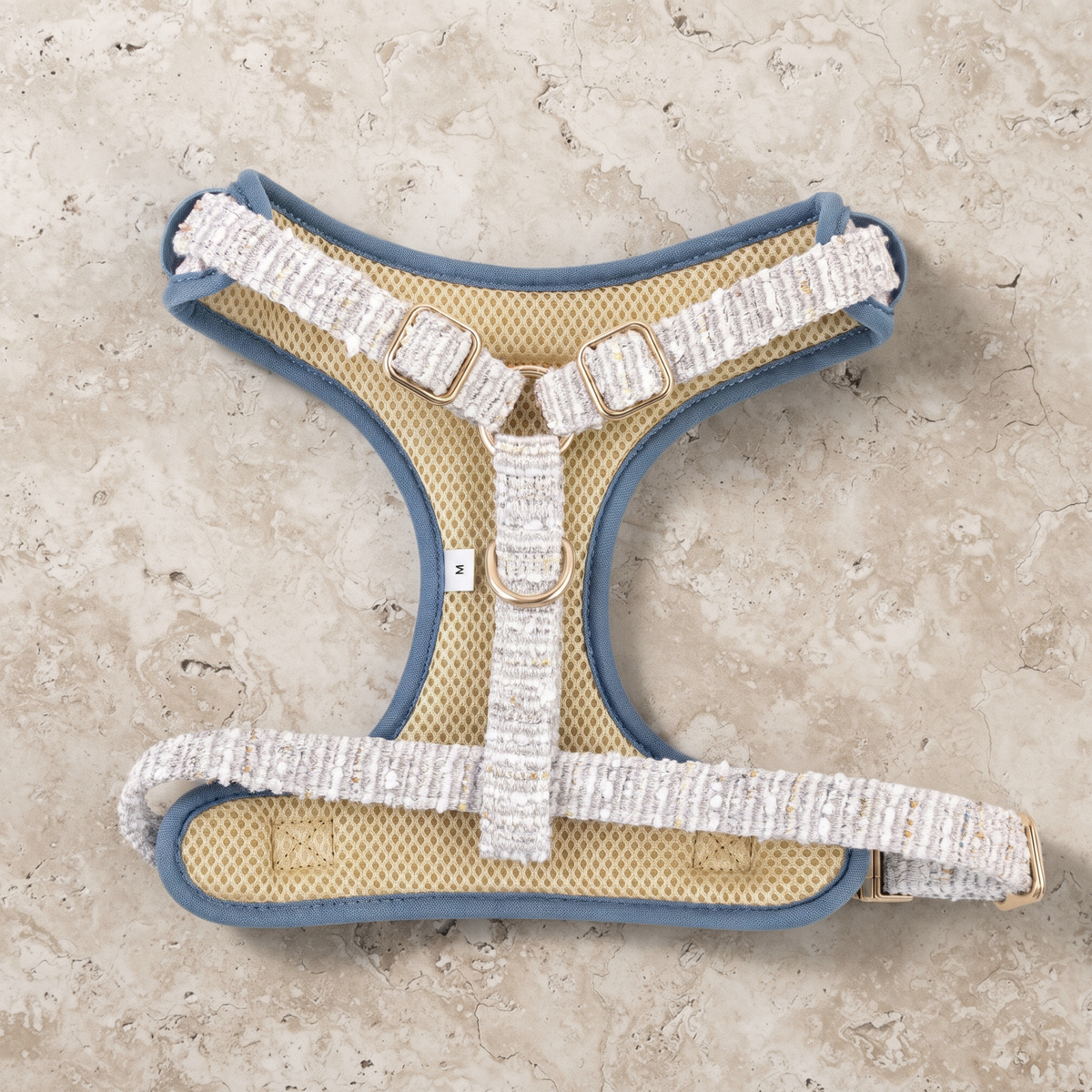 Dog harness with light blue tweed straps, blue trim, and matte gold buckles
