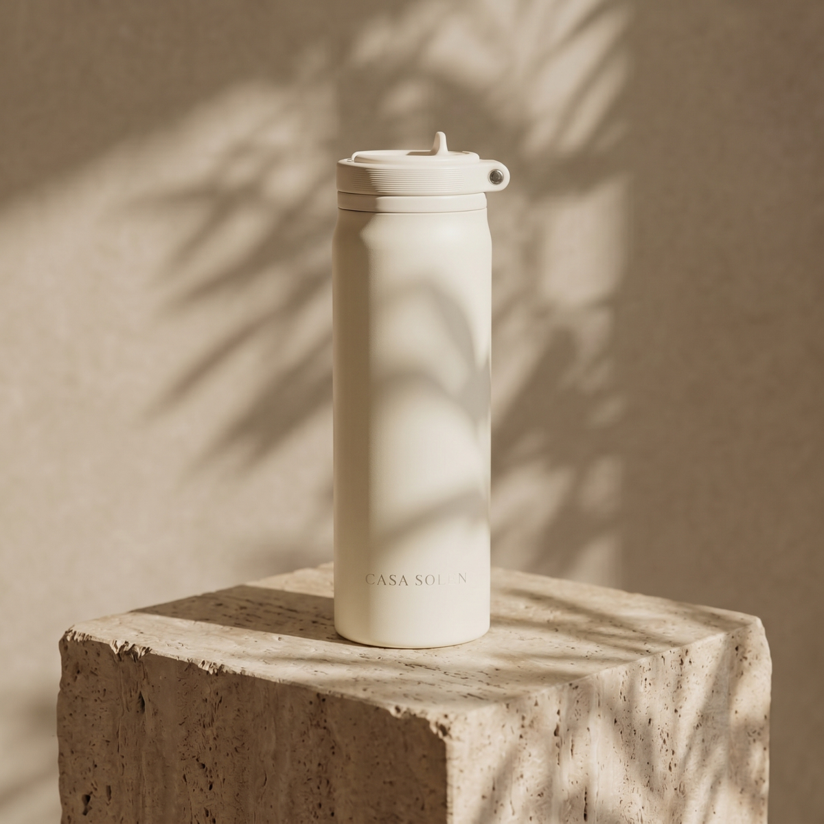 Sandy oat insulated stainless steel drink bottle with flip lid, standing on pedestal